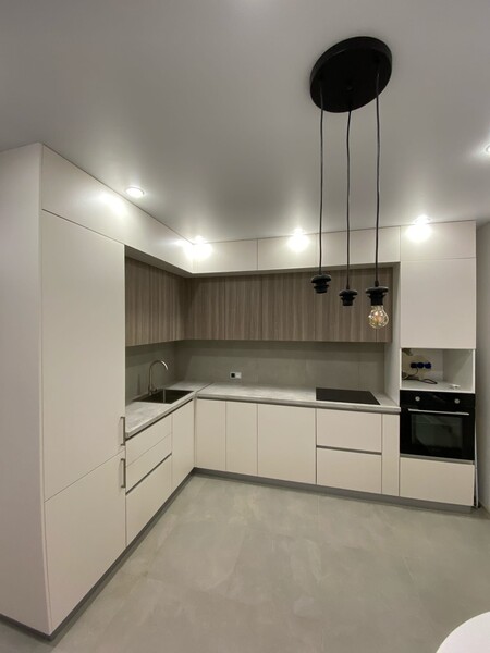 Белая угловая кухня в 2 уровня под потолок