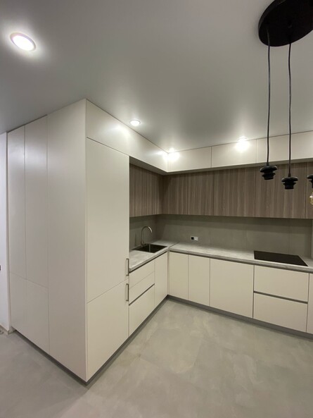 Белая угловая кухня в 2 уровня под потолок